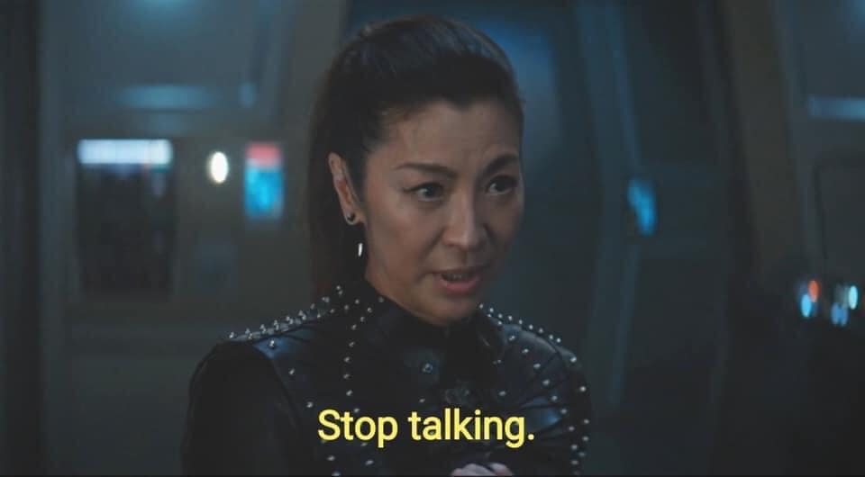 The meme features a screenshot from the TV show "The 100" with a character, Clarke, looking stern and disapproving. The text overlayed on the image is "Stop talking" and "In a way that hurts me".